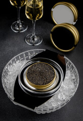 Elegant composition with champagne and caviar.Two champagne glasses, a bottle with a gold label and...