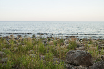 Summer evening on a lake shore with big stones