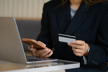 Young businesswoman with credit card doing online shopping on her smartphone