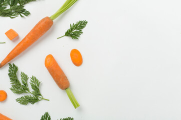 Flat lay with fresh carrots and leaves on white background, top view