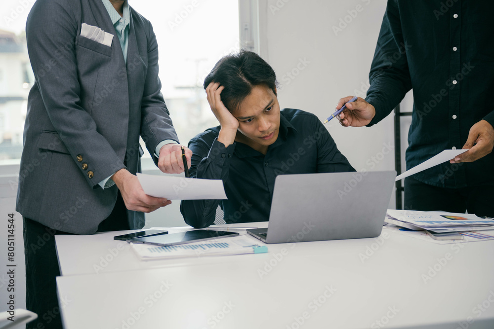 Poster a man is sitting at a desk with a laptop and papers in front of him