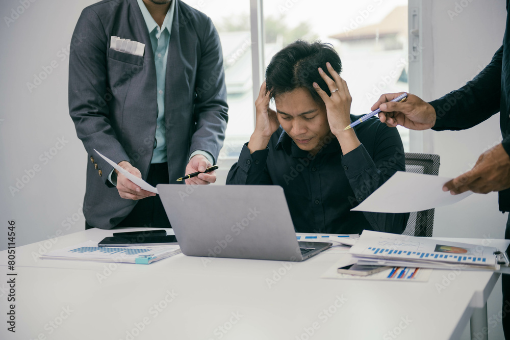 Poster a man is sitting at a desk with a laptop and papers in front of him
