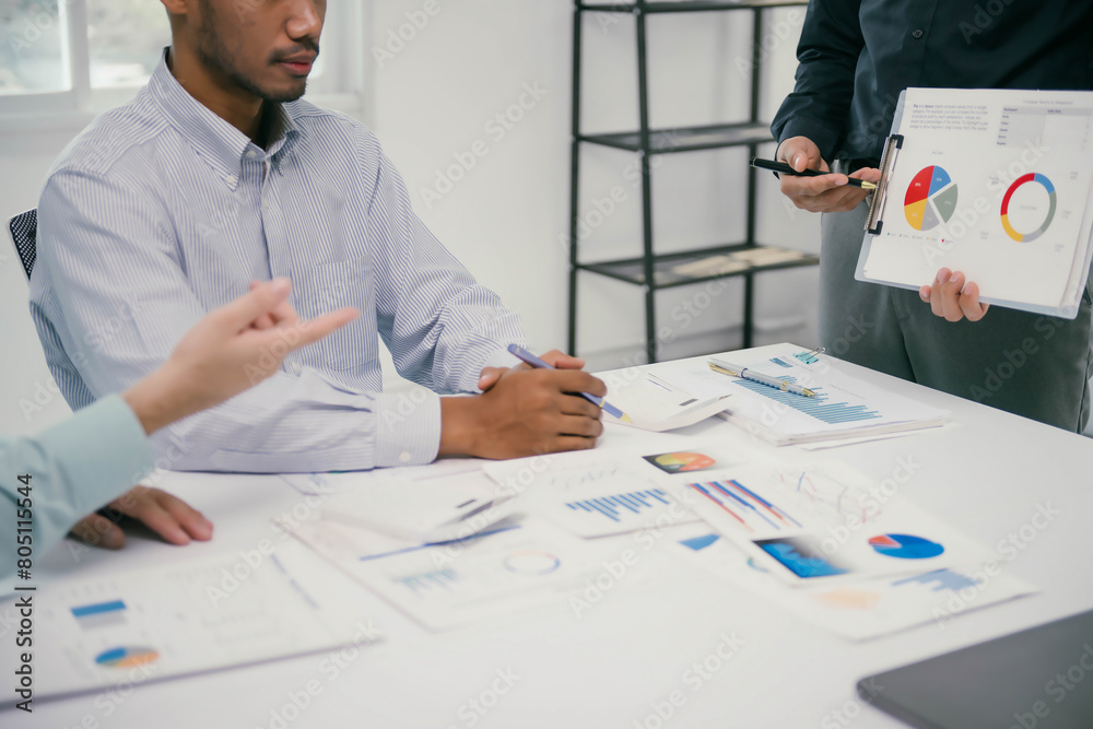 Poster a man is holding a clipboard with pie charts and is talking to two other men
