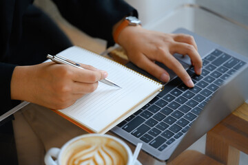 Cropped shot businesswoman writing down ideas or planning next weekend on notebook