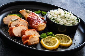 Chicken Saltimbocca - pan-fried chicken cutlets wrapped in Italian prosciutto slices on black...