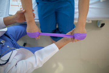 doctor is examining muscle injury and using elastic bands test injury and also help with physical...