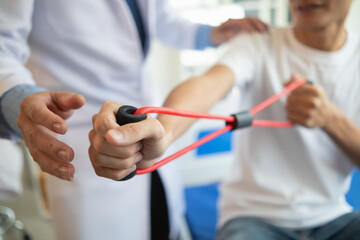 doctor is examining muscle injury and using elastic bands test injury and also help with physical therapy strengthen muscles because physical therapy will help strengthen muscles and help blood flow.