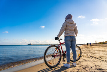 Mid-adult woman riding bicycle at seaside
