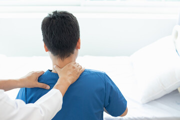 man was admitted for treatment of muscle pain in back of his shoulder due to working hard and causing muscle inflammation. doctor is treating man muscle pain in his back and shoulders due to overwork.