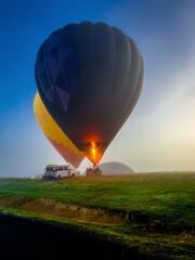 A brightly colored hot air balloon in morning fog landscape Melburne, Australia. Yarra valley...