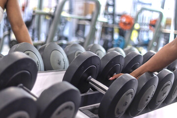 Black woman hand holding a dumbbell at the gym, with copy space