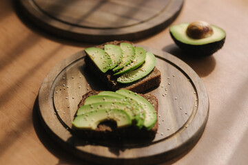 Two pieces of bread with avocado slices and sesame on top. Vegan food