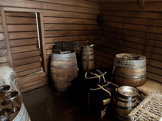 Interior cargo bay area of a wooden historical ship with barrels and ropes, Nao Victoria replica