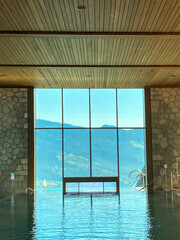 Swimming Pool with Window View over Mountain in a Sunny Summer Day in Switzerland.