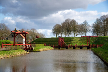 View of canal and rampart with entrance bridges around the village of Bourtange (former Fort Bourtange), near Westerwolde the Netherlands; the fortress was built in 1593 shape of a star  - obrazy, fototapety, plakaty