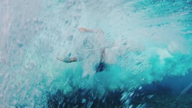 Female surfer takes off and falls from lip of the wave in the Maldives