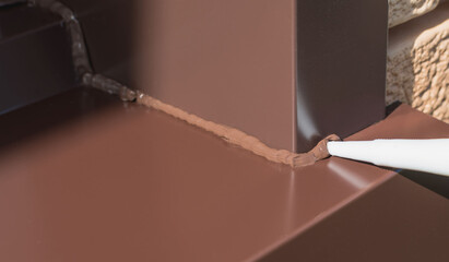Applying silicone sealant to a metal joint