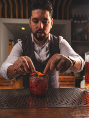 Expert bartender garnishing cocktail at bar