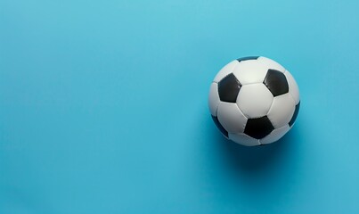 Top view photo of white and black soccer ball as football concept . Minimalist flat lay image of leather football ball over blue turquoise background with copy space