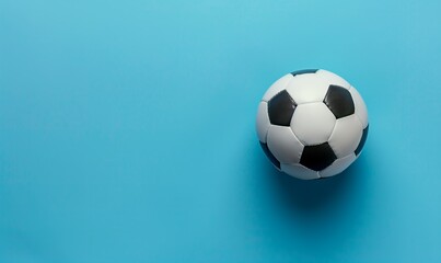 Fototapeta premium Top view photo of white and black soccer ball as football concept . Minimalist flat lay image of leather football ball over blue turquoise background with copy space