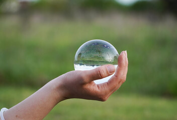 Crystal Sphere. Crystal Sphere, used for meditation, clairvoyance, health, luck and abundance! Hands covering the crystal sphere. Day photo. Crystal sphere in various angles.Various backgrounds. 