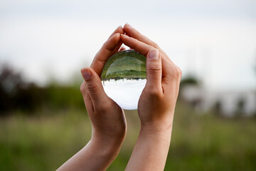 Crystal Sphere. Crystal Sphere, used for meditation, clairvoyance, health, luck and abundance! Hands covering the crystal sphere. Day photo. Crystal sphere in various angles.Various backgrounds. 