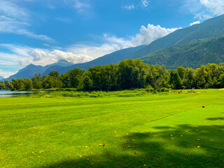 Golf Course with Mountain View and Clouds in a Sunny Summer Day in Granges, Valais in Switzerland.