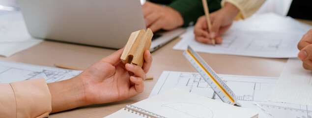 Professional architect team discussion about architectural project on meeting table with blueprint...