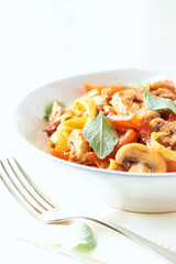 Pappardelle Pasta with chicken breast, red pepper and champignons. Bright background. Close up.	