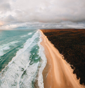 High angle aerial drone view of famous Seventy Five Mile Beach, 75 mile beach on Fraser Island, Kgari, Queensland, Australia, shortly before sunset
