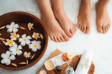 Couple indulges in blissful foot massage at luxurious spa salon for reflexology therapy in gentle...