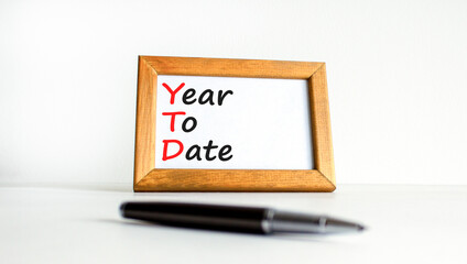 YTD year to date symbol. Concept words YTD year to date on beautiful wooden frame. Beautiful white background. Business YTD year to date concept. Copy space.