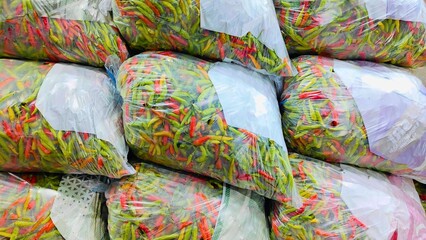 Many of the chili peppers are in plastic bags for sale.