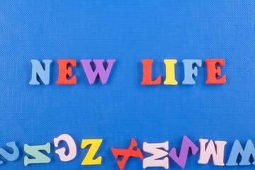 NEW LIFE word on blue background composed from colorful abc alphabet block wooden letters, copy space for ad text. Learning english concept.