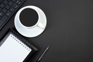 black office table with computer, pen and a cup of coffee, lot of things. Top view with copy space.