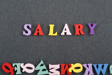 SALARY word on black board background composed from colorful abc alphabet block wooden letters,...