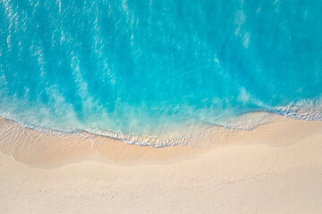 Summer seascape beautiful waves, blue sea water in sunny day. Top view from drone. Sea aerial surf, amazing tropical nature background. Mediterranean bright sea bay, waves splashing beach sandy coast