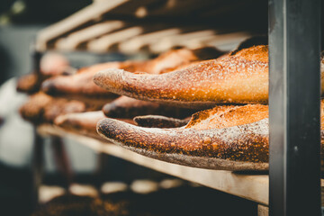 Freshly baked baguettes in a shelf cart in a bakery