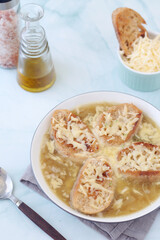 A ceramic bowl with French onion soup	