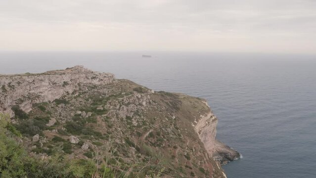 A view from Dingli Cliffs, Malta, on a misty day, showing Filfla Island in the distance. 