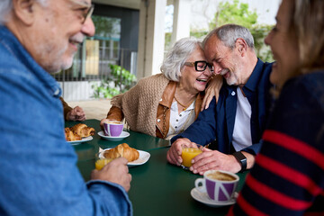 Romance in the elderly. Group of happy residents friends of a geriatric. Mature gray hair at coffee...