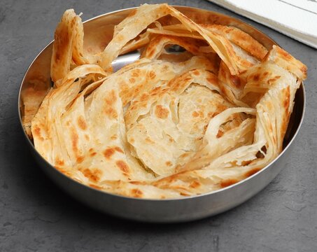 Delicious Indian parotta, a flaky, layered flatbread, served hot and fresh. Golden brown and irresistible, perfect for showcasing authentic Indian cuisine
