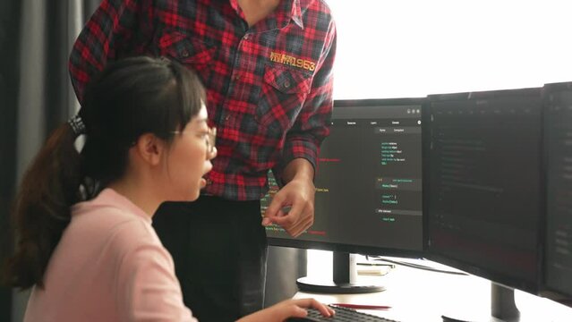 Slow motion back end or software developer manager supervising his team on new application program development on debugging and solving complex code algorithms on monitor. Burgeoning