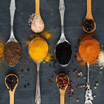 Various spices on tablespoons and small spice spoons