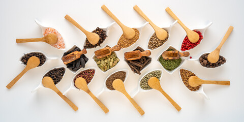 Exotic spices in bowls with small wooden spoons