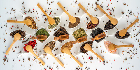 Many different spices in porcelain bowls with wooden spoons