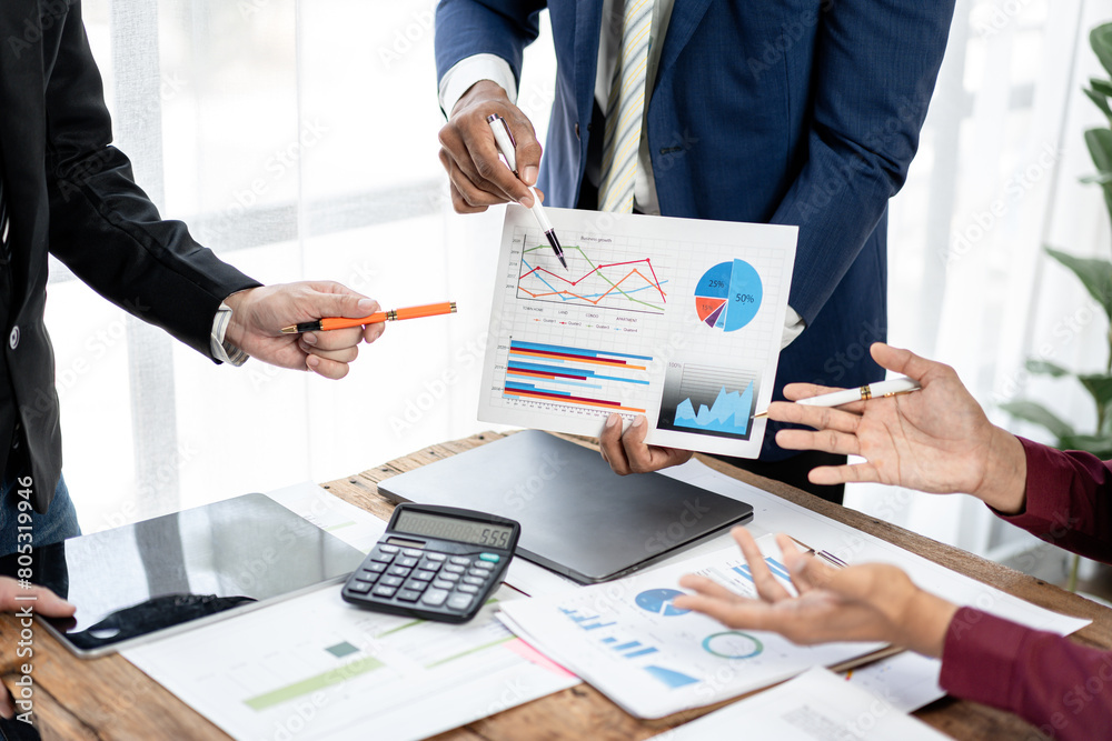 Poster A group of people are gathered around a table with a large graph on it