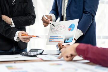 A group of people are looking at a graph and discussing it