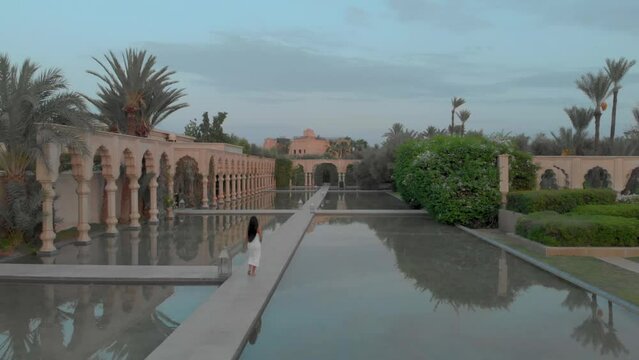Beautiful Woman walking near the water, Palais namaskar, Luxury oasis in Marrakech, Morocco