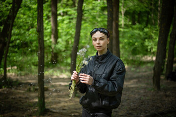 Fototapeta premium Girl Walking Through Forest Holding Dandelions